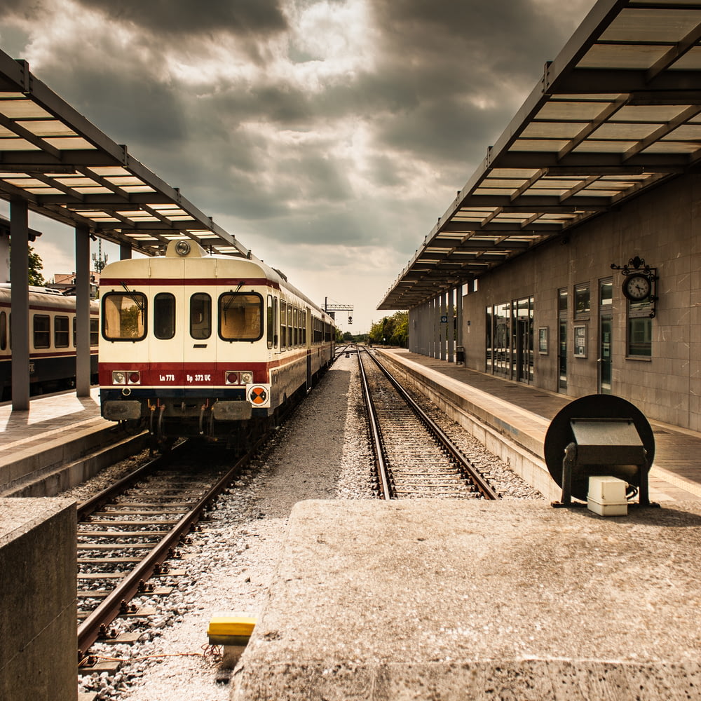 Foto della stazione ferroviaria bianca e rossa sotto il cielo nuvoloso grigio