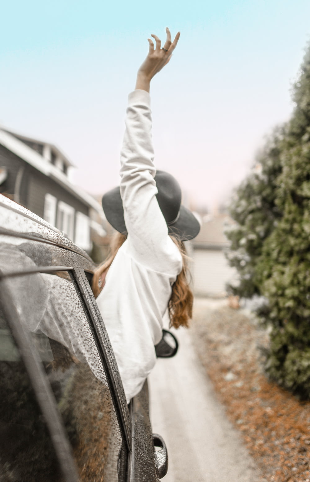mulher levantando a mão esquerda na janela do veículo durante o dia