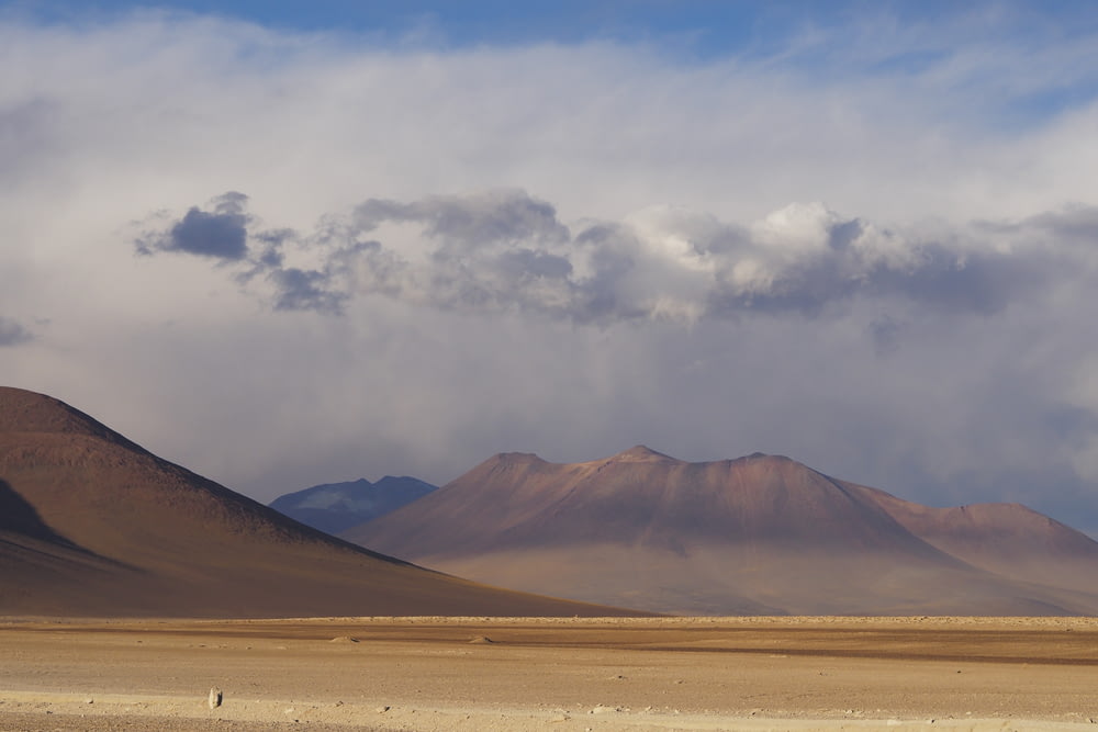 brown mountain beside desert during daytime