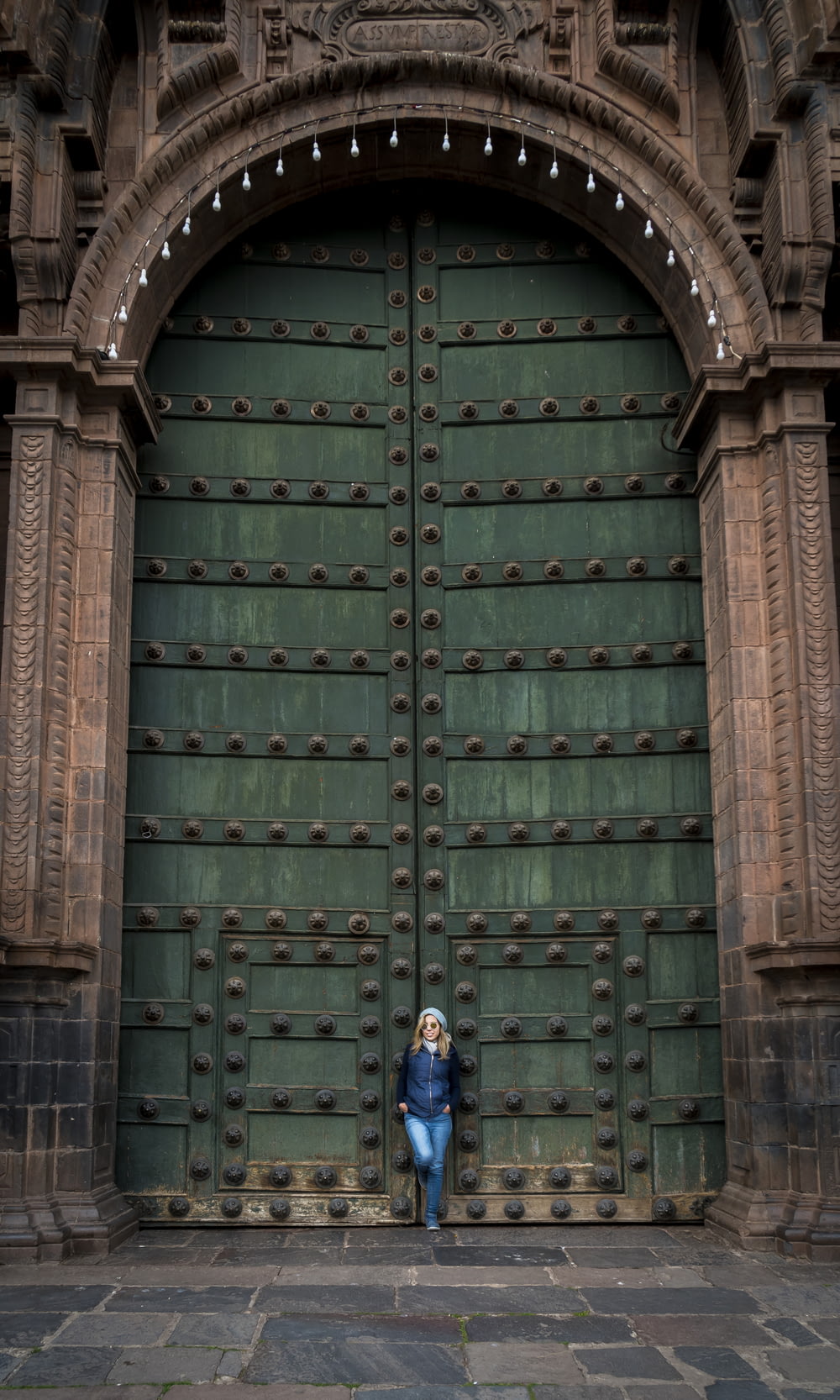 woman leaning on large green door