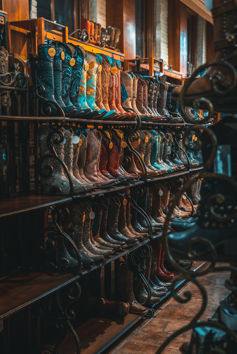 brown and blue leather cowboy boots on rack