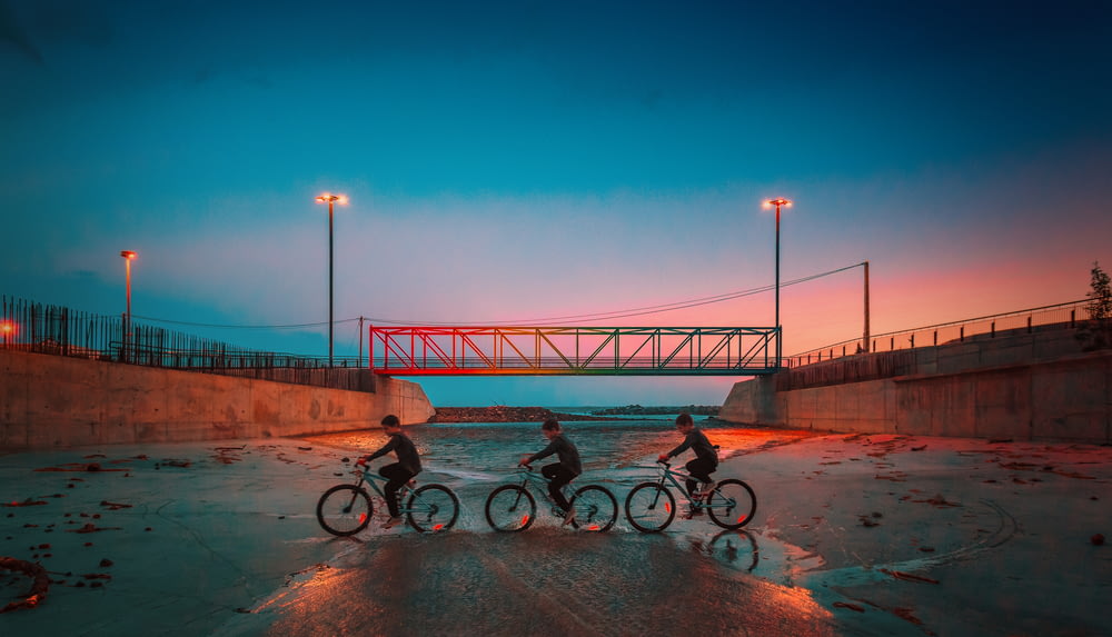 three boys riding on bicycles