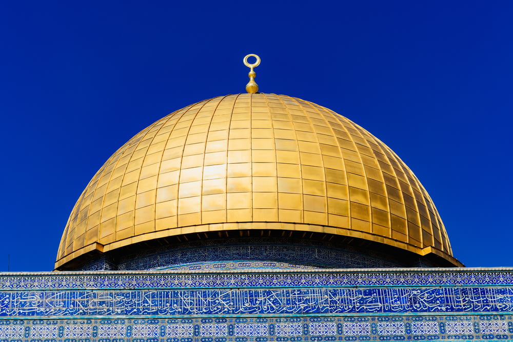 Edifício da cúpula dourada sob o céu azul durante o dia