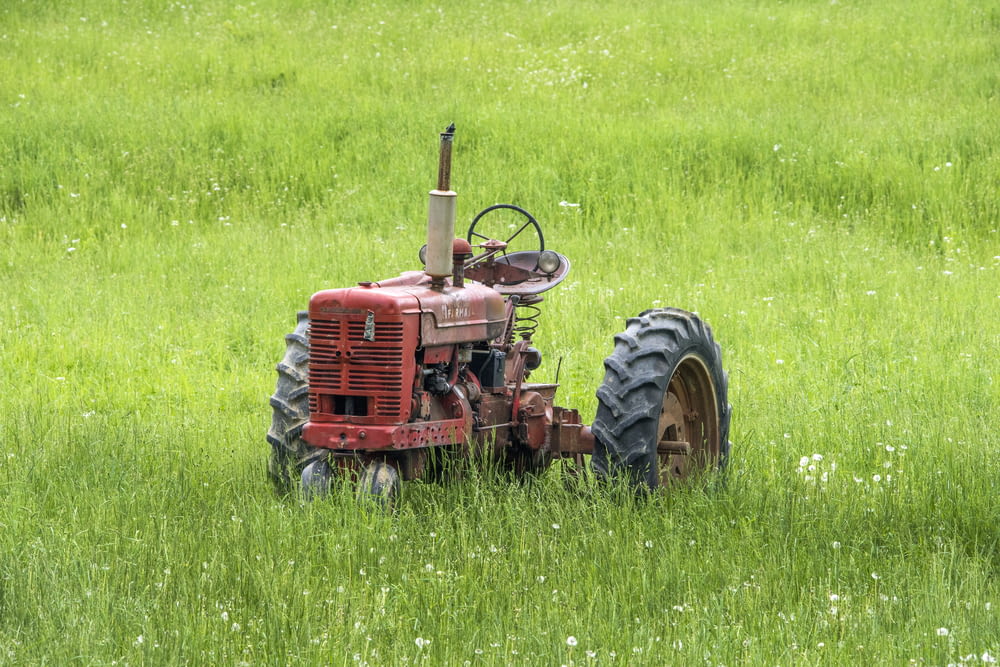 red tractor left in grass field