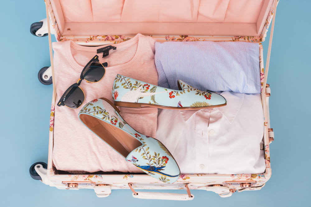 vêtements et paire de chaussures dans les bagages