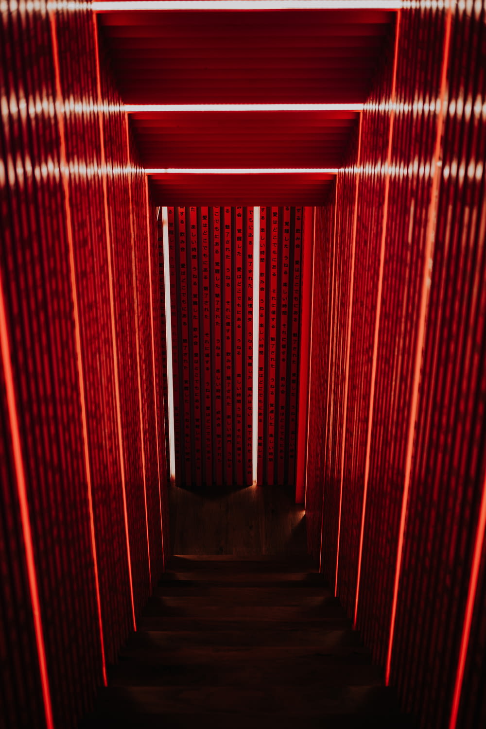 Escada estreita cinza com parede vermelha