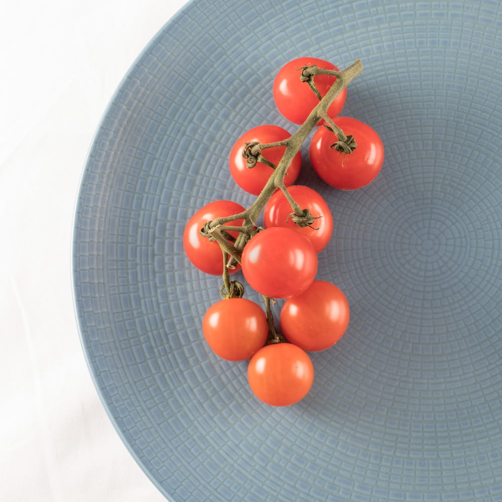 top view photography of tomatoes on plate