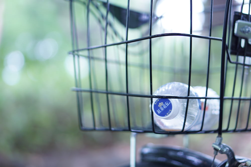 clear plastic bottle in black bicycle basket