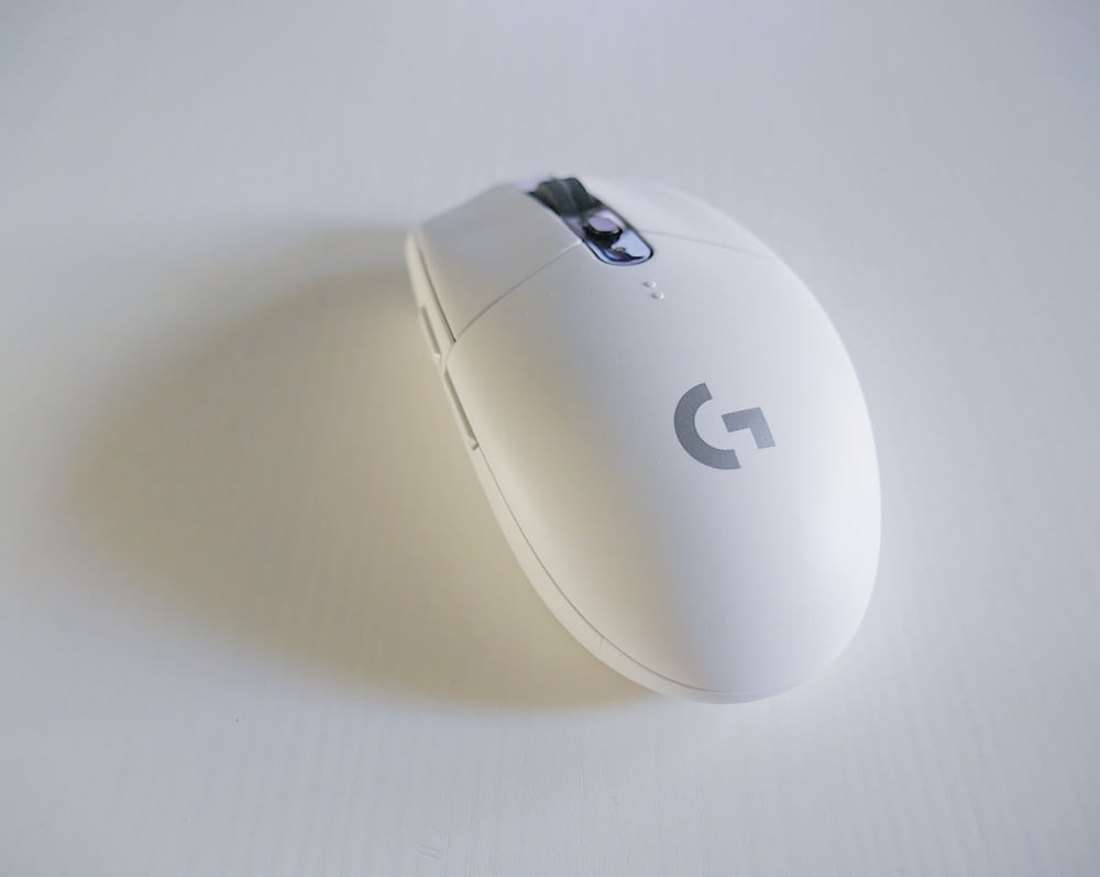 흰색 표면에 흰색 및 회색 로지텍 G 시리즈 무선 마우스