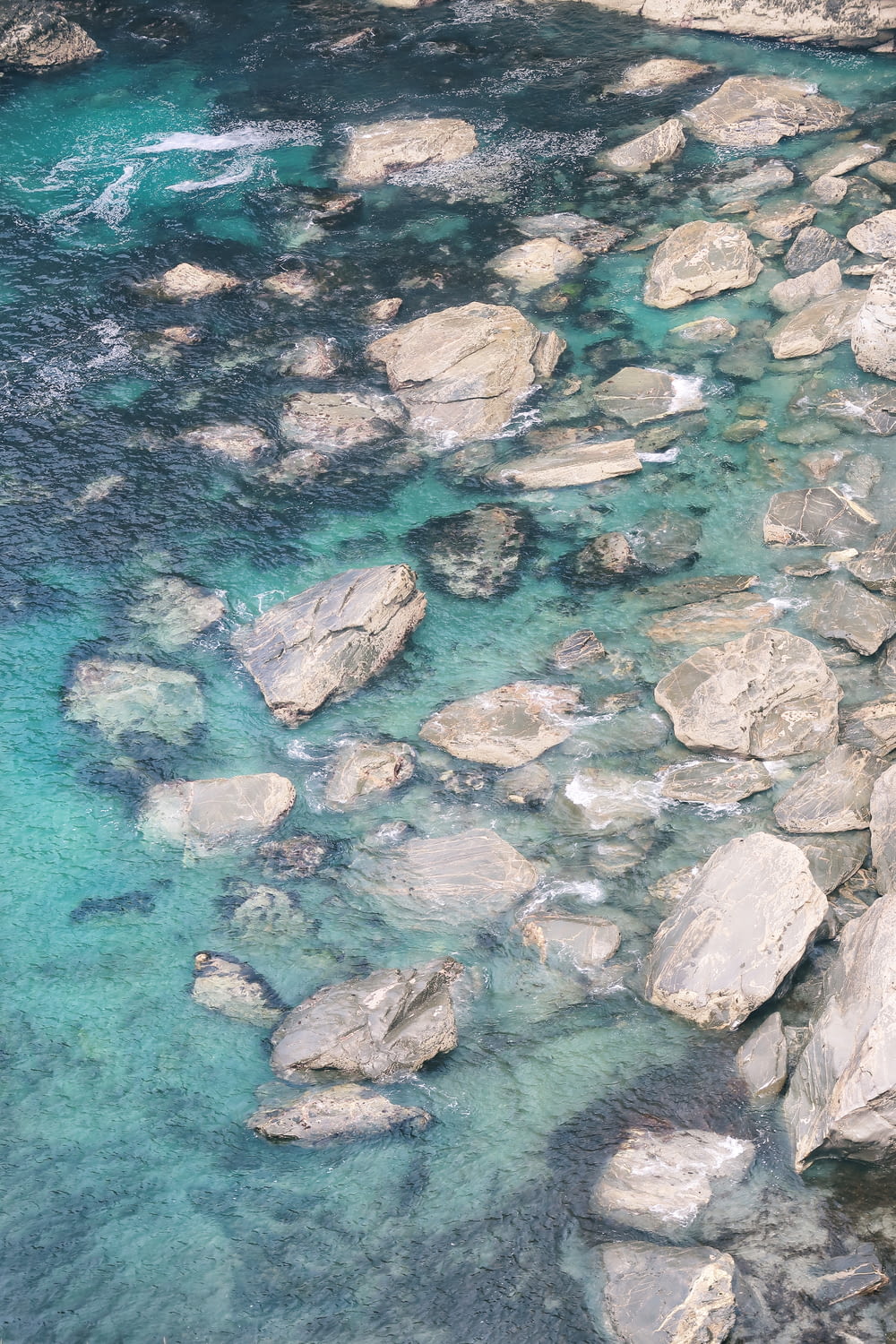 aerial photography of gray rocks and body of water at daytime