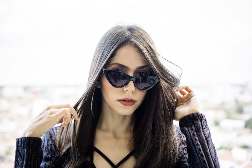 woman wearing black cateye sunglasses taking selfie
