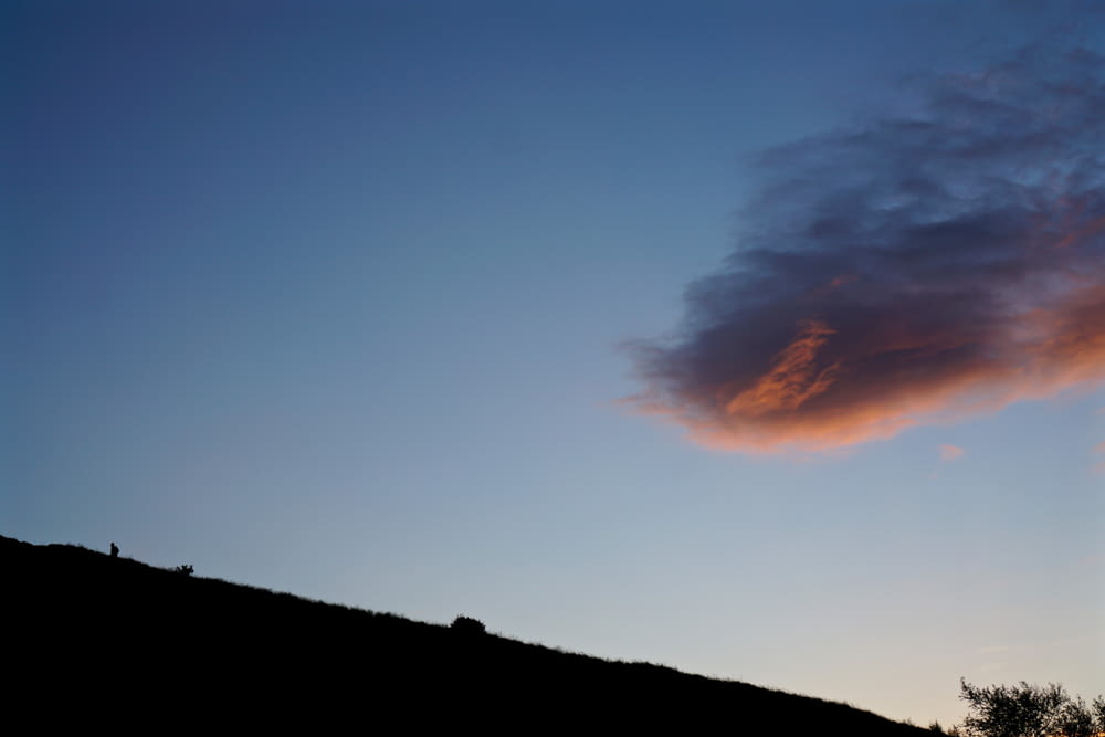 silhouette de pente de montagne sous ciel nuageux