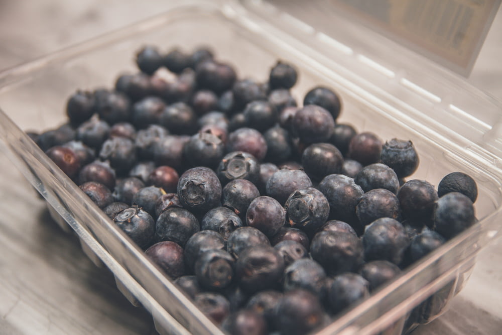 shallow focus photo of blueberries on clear plastic case