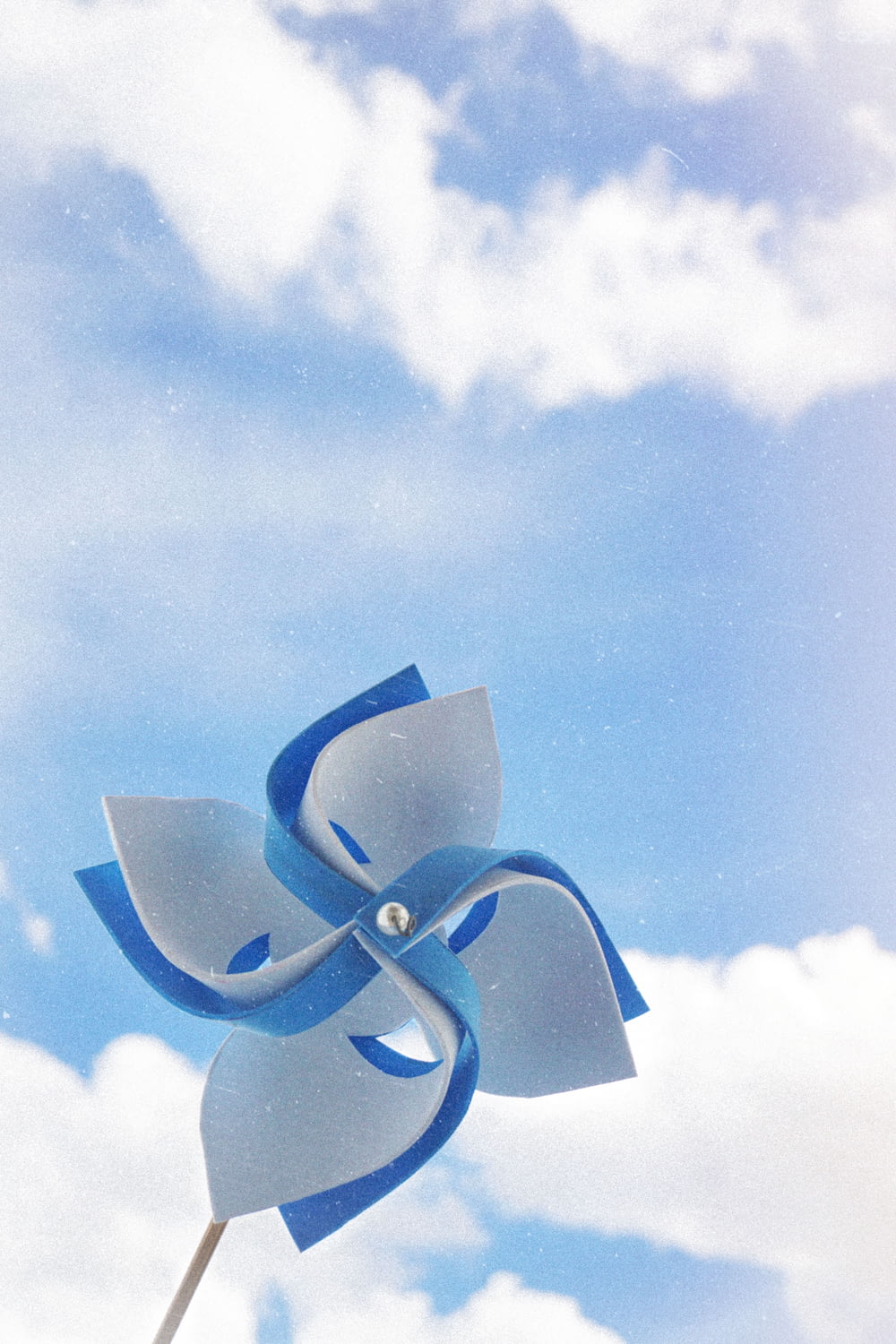 曇り空の下の白と青の手持ち式風車