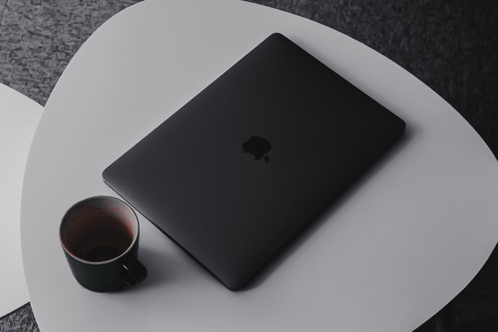 MacBook Pro beside mug on table