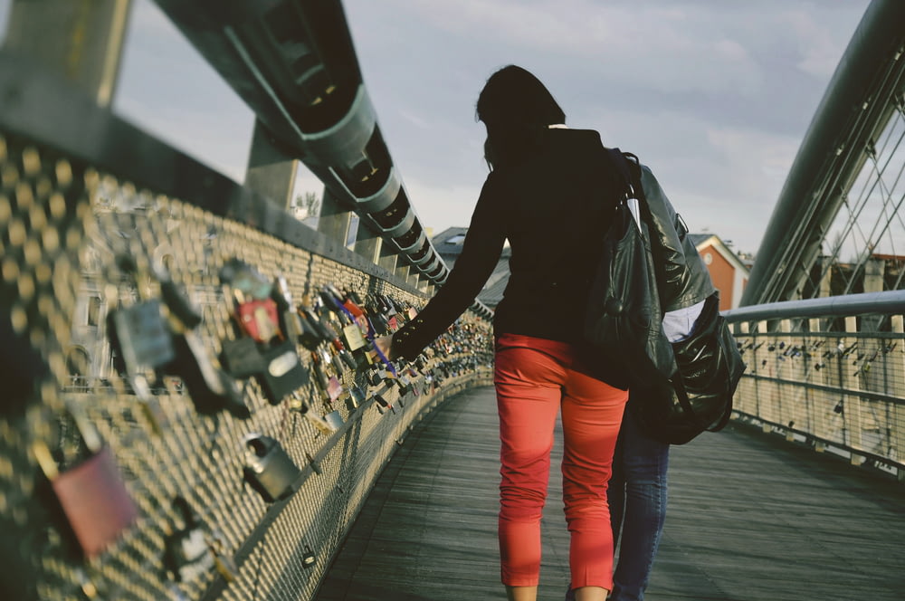 woman standing on bridge with locks