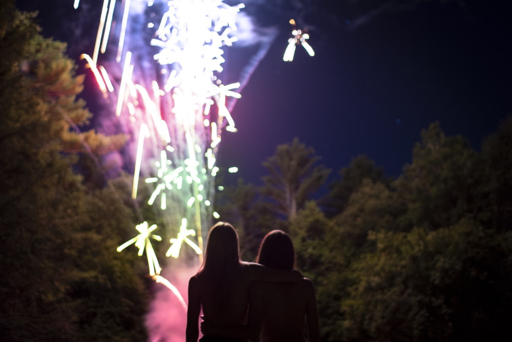 two people standing near firework show