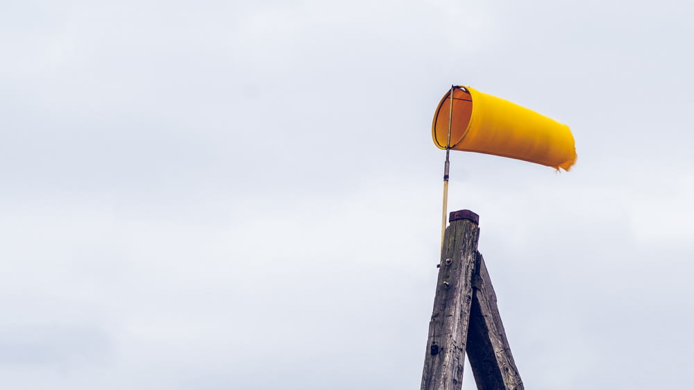 lanterna de ar amarela no poste de madeira marrom