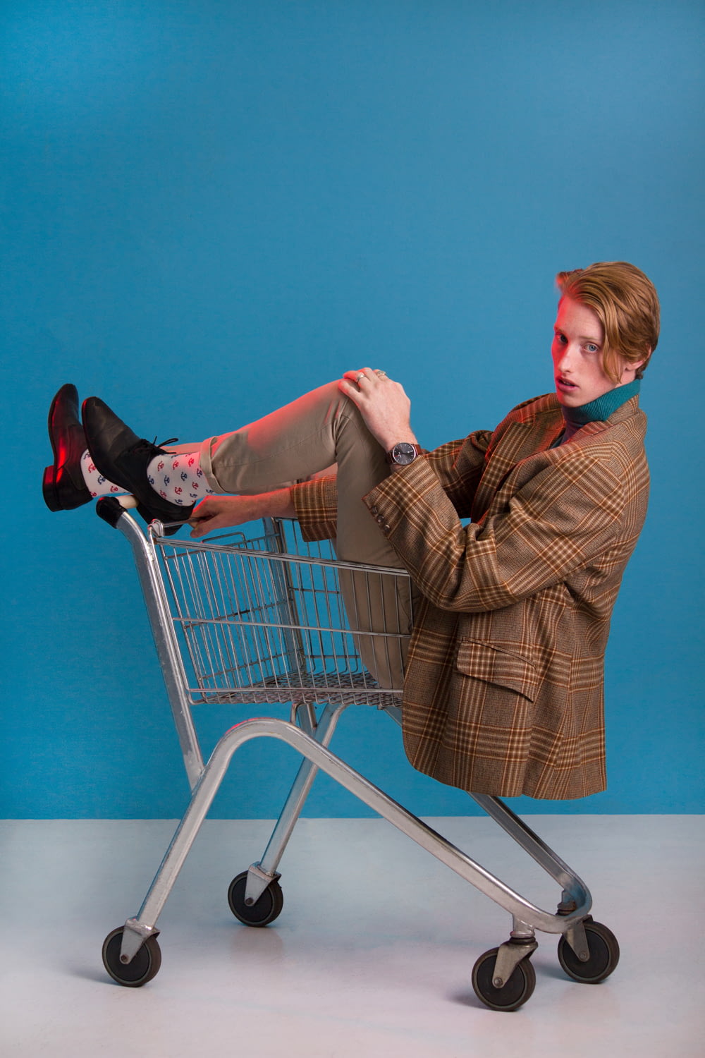 man in brown jacket sitting in shopping cart