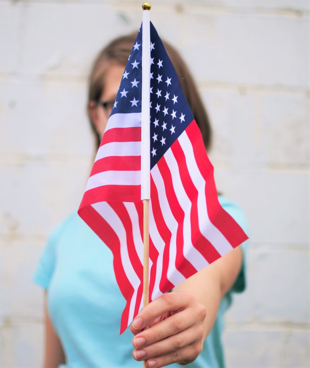 pessoa segurando a bandeira dos EUA