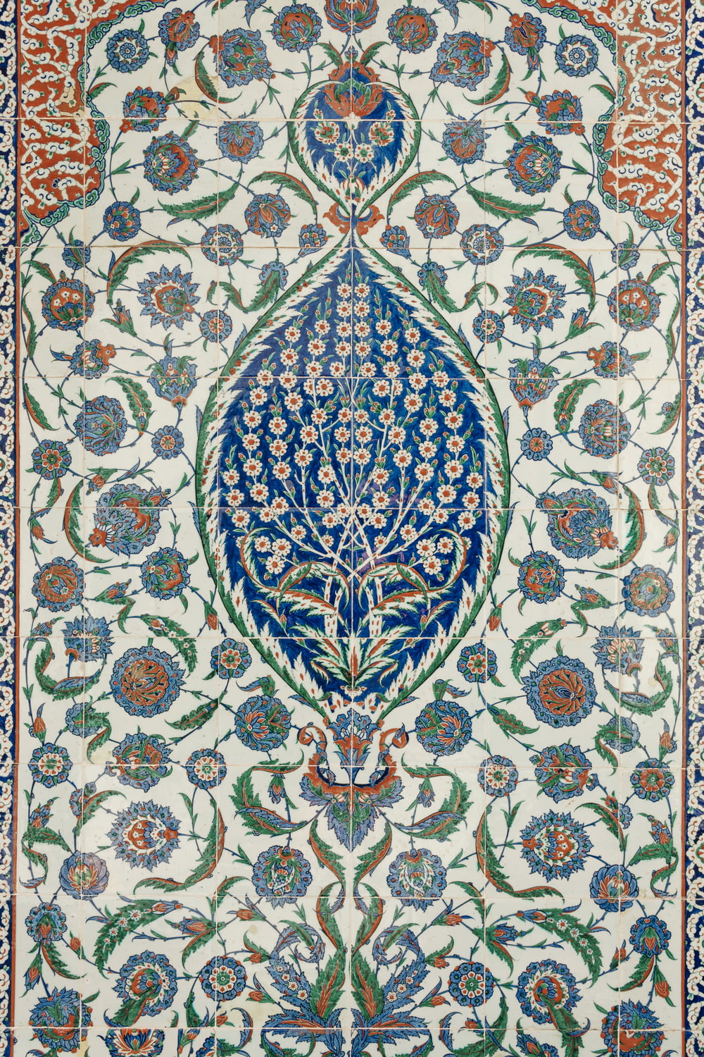 Ein aufwendig gestalteter Teppich mit blauen und grünen Blumen