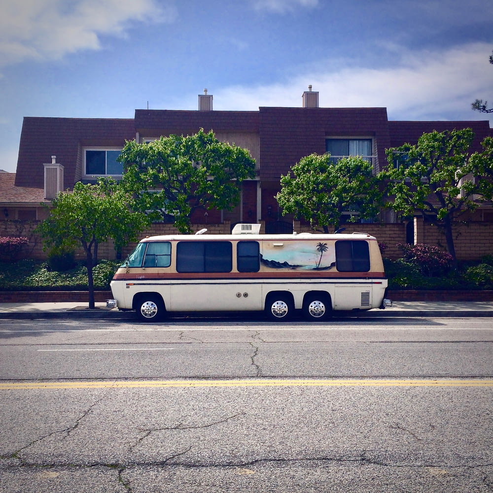 white van parked outside brown house
