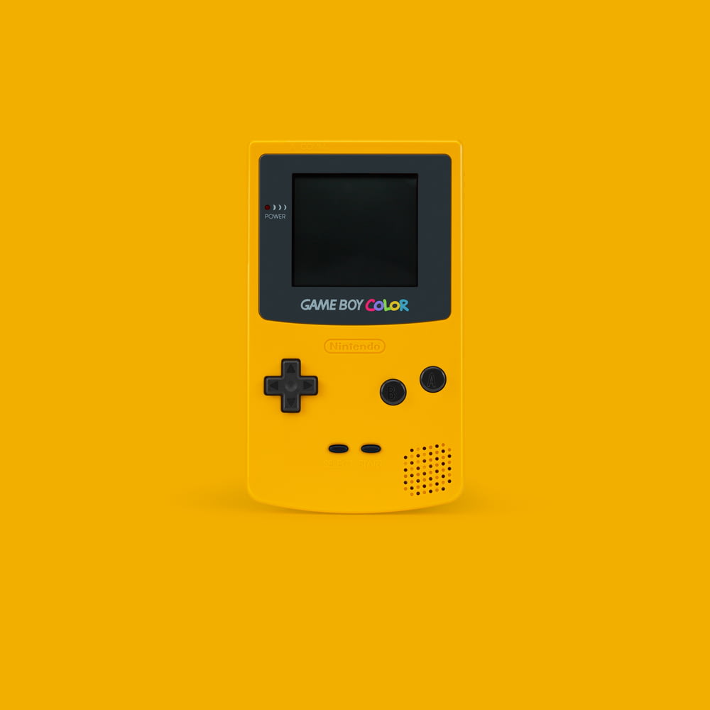 blanco y negro Nintendo Game Boy Color sobre superficie amarilla
