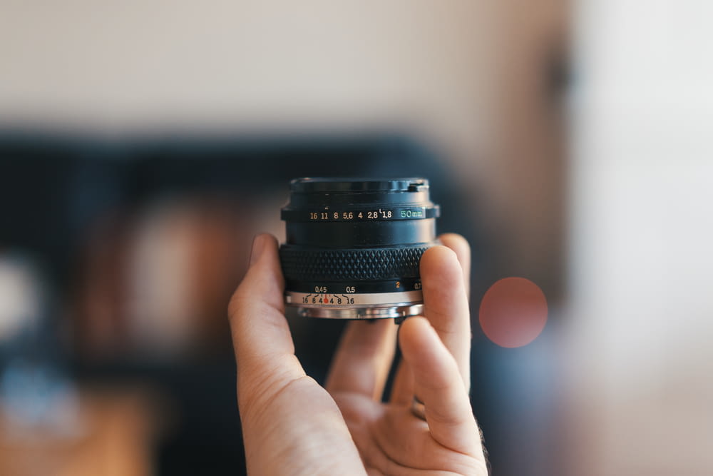 selective focus photography of person holding camera lens