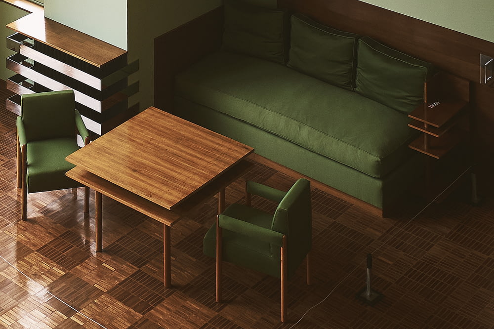 canapé en cuir vert près du mur devant la table