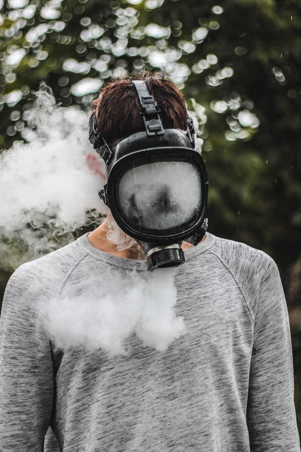 a man wearing a gas mask with a lot of smoke coming out of his mouth
