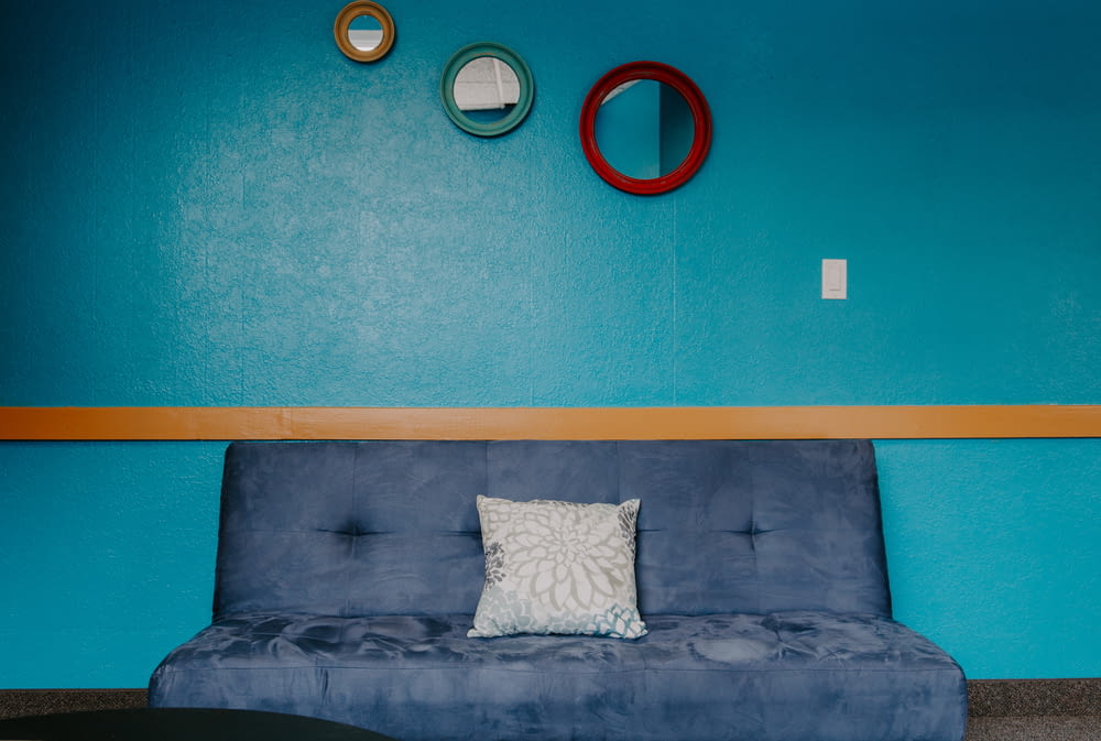 blue 3-seat sofa with throw pillow