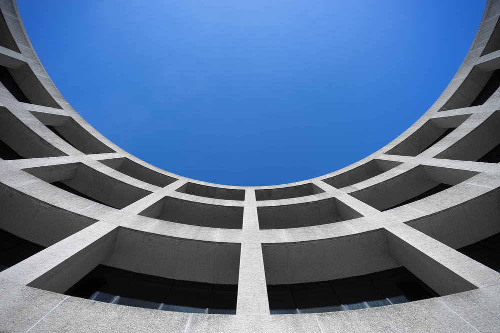 low angle photography of gray concrete building at day time