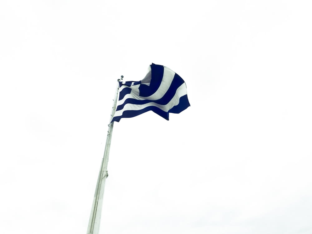 Fotografía de ángulo bajo de bandera blanca y azul ondeando