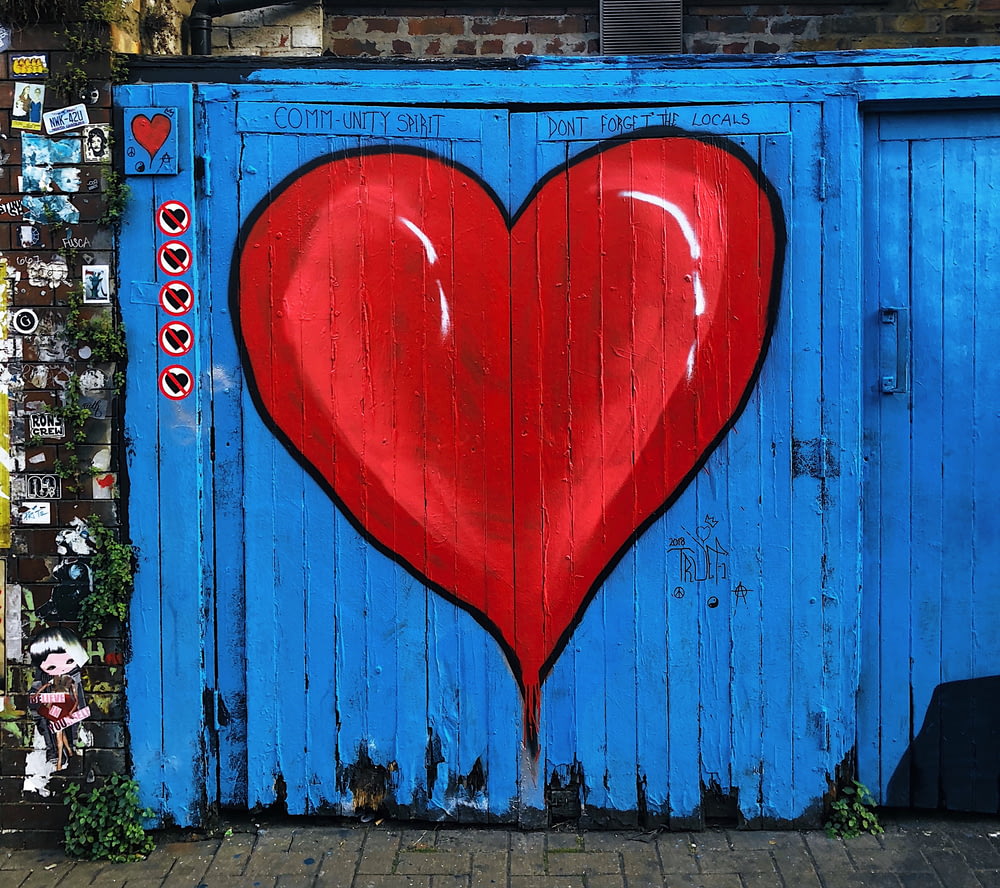 Portail en bois bleu avec un cœur rouge peint dessus