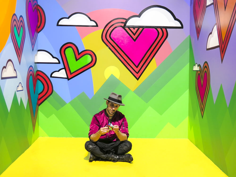 여러 가지 빛깔의 3D 벽지 방에 앉아있는 남자