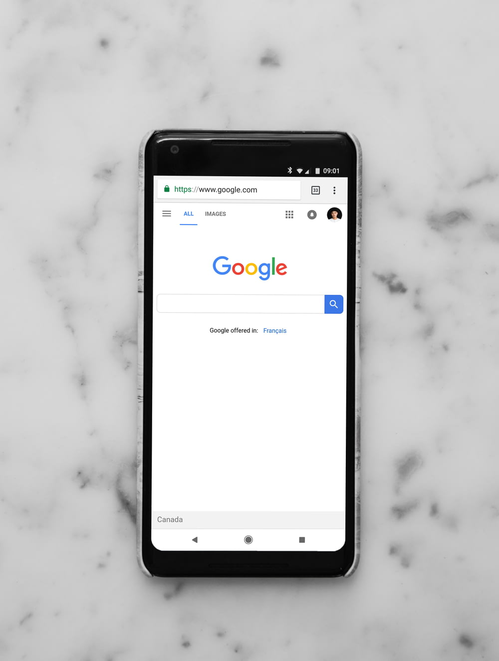 白い表面にグーグルサイトを示す黒いAndroidスマートフォン