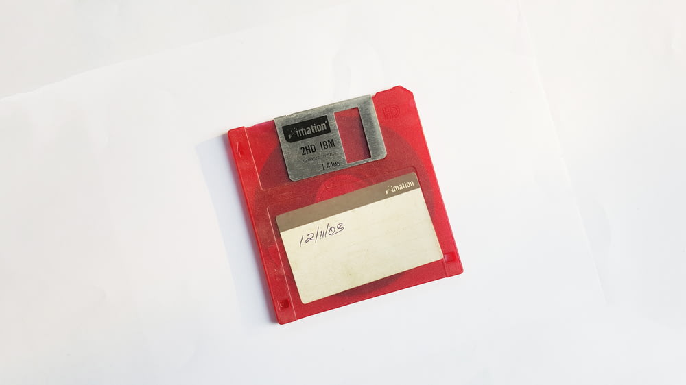 disquete vermelho e branco na superfície branca