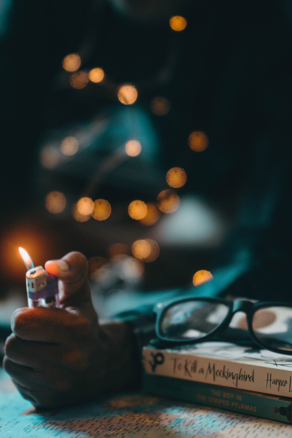 selective focus photography of person lighting up lighter with bokeh background