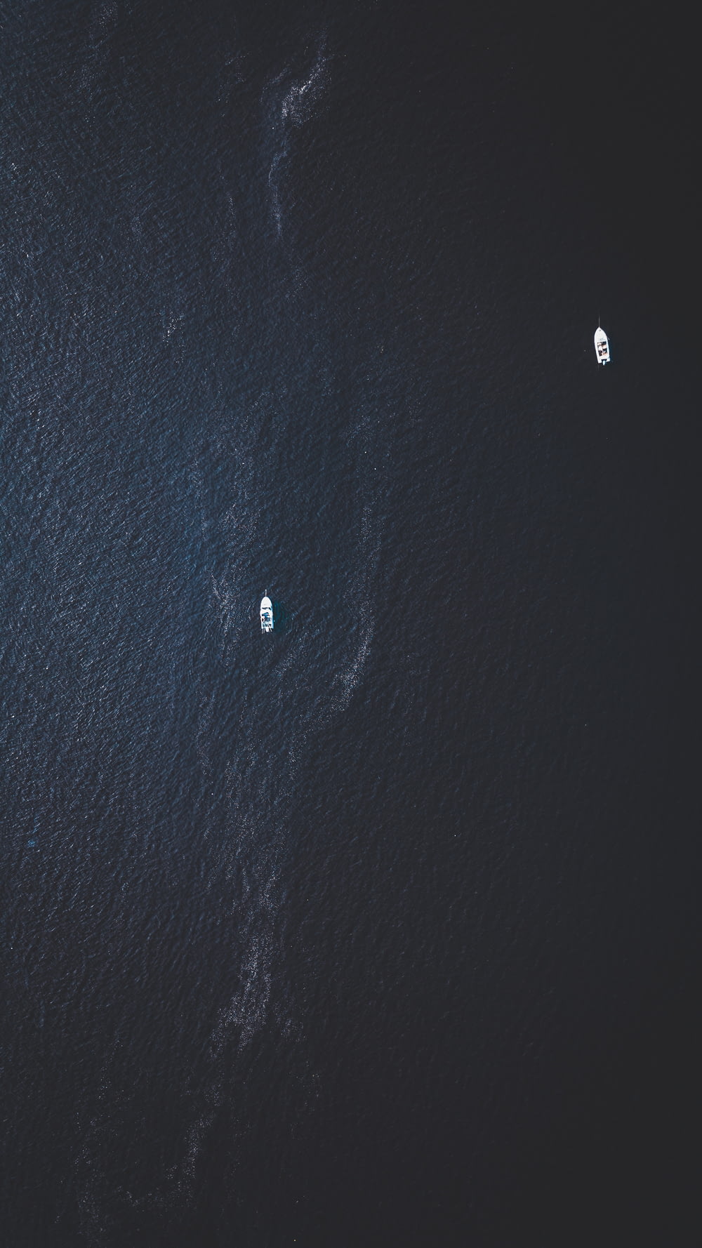 top view photography of two white boats on water at daytime