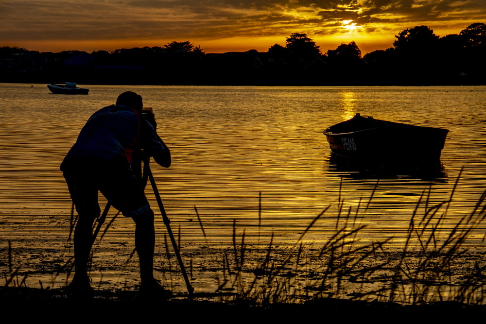 silhouette photography of a man taking picture on boat