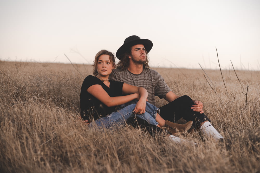 Frau und Mann sitzen auf Weizenfeld