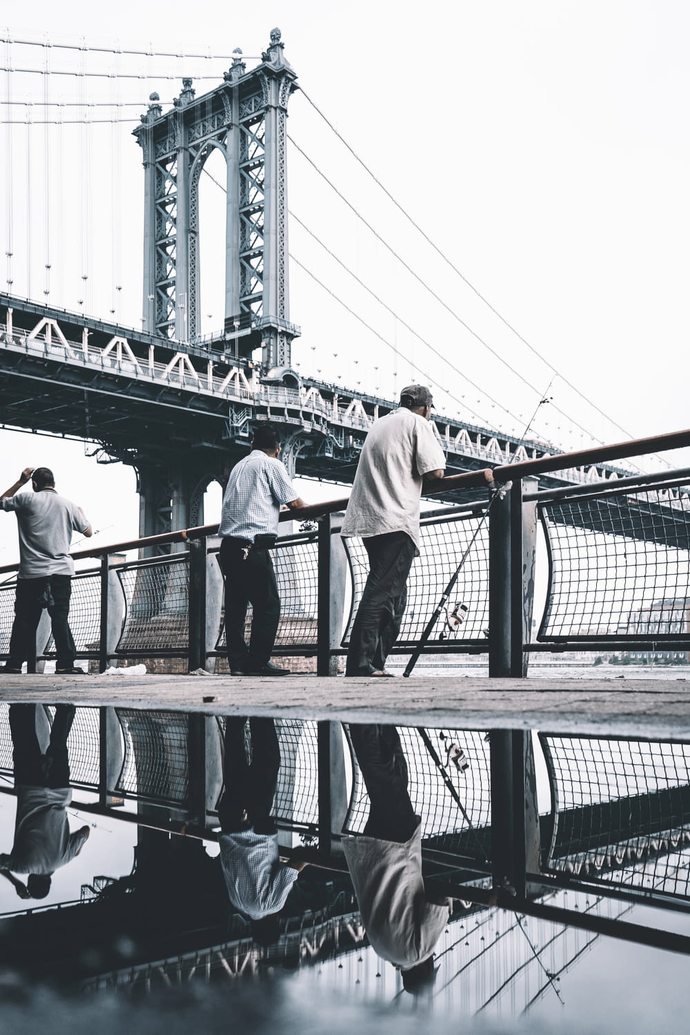 three men standing near bridge