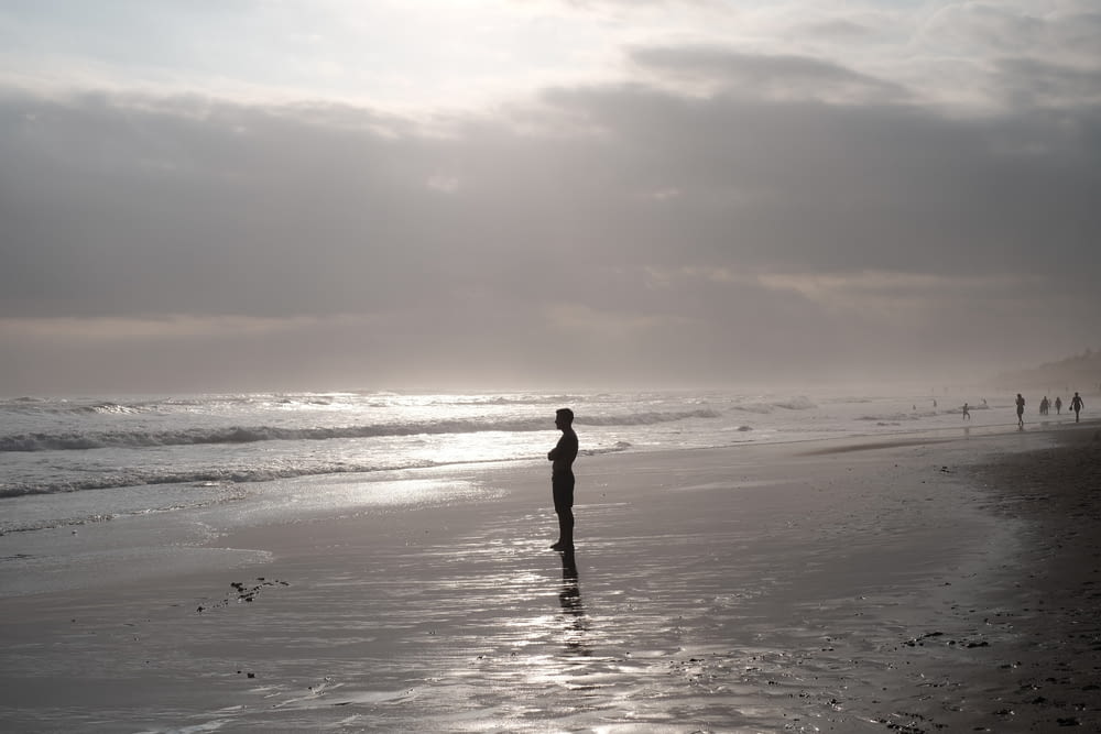 Silhouette eines Mannes, der am Strand steht