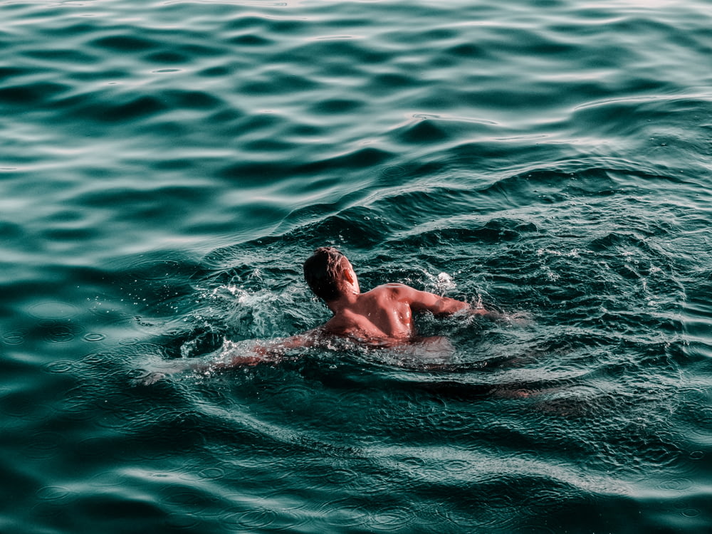 man swimming on water