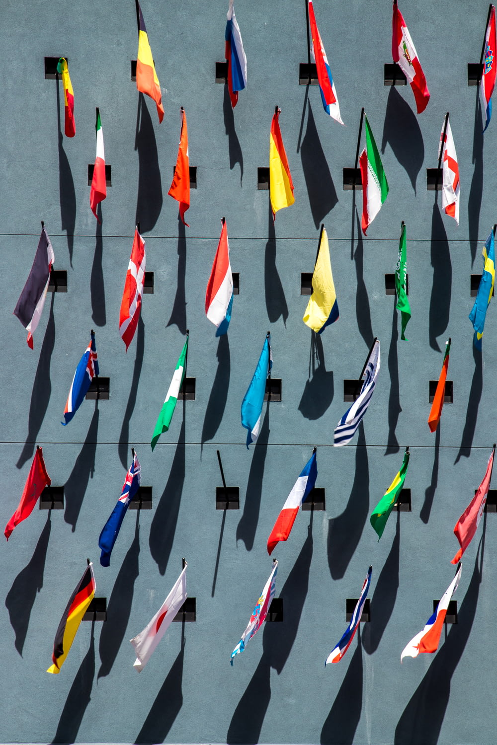 Photo de drapeaux nationaux de couleurs assorties sur le mur pendant la journée