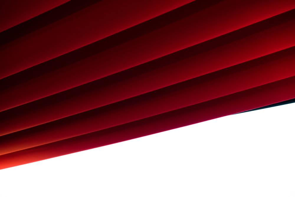 Un primo piano di una tenda rossa con uno sfondo bianco