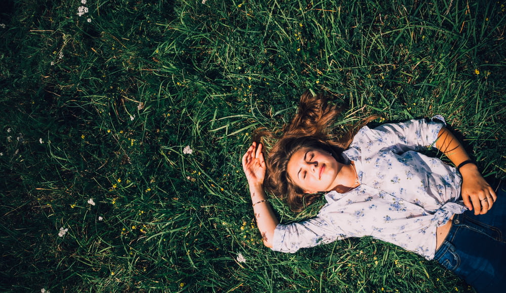 mulher deitada na grama durante o dia