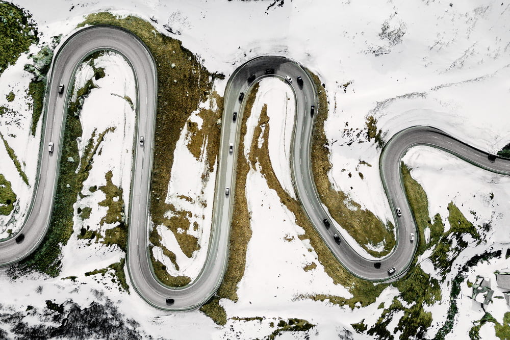Luftaufnahmen von Fahrzeugen auf einer Straße, die tagsüber von Schnee umgeben ist