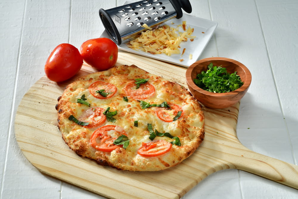pizza cuite sur une planche à pizza en bois brun