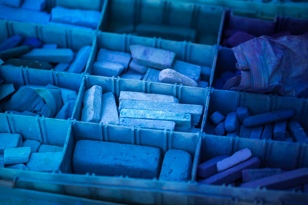 uma caixa azul cheia de muitas rochas de cores diferentes
